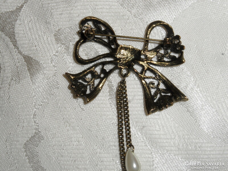 Older bow-shaped metal badge, brooch