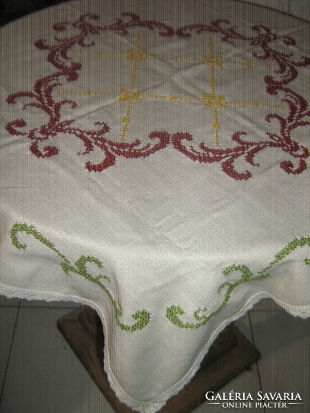 Beautiful cross-stitch embroidered tablecloth with a baroque pattern and a lace edge