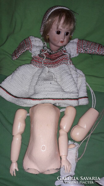 A truly antique vintage toy doll with a wooden body with an antique porcelain head and an authentic clothing variation, collectible 35 cm