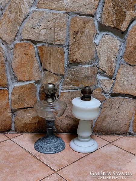 A petroleum lamp with a metal base and a milk glass lamp together.