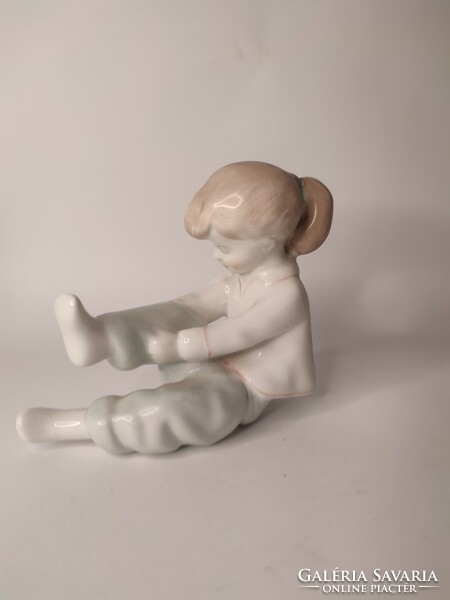 Aquincum porcelain figure of a little girl dressing up