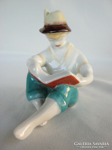 A boy reading a book from Hollóháza porcelain