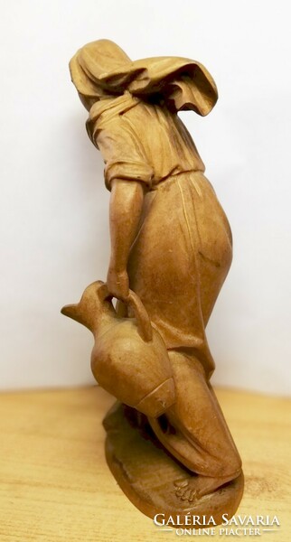 Antique carved statue. Girl with a jar of sandalwood wood