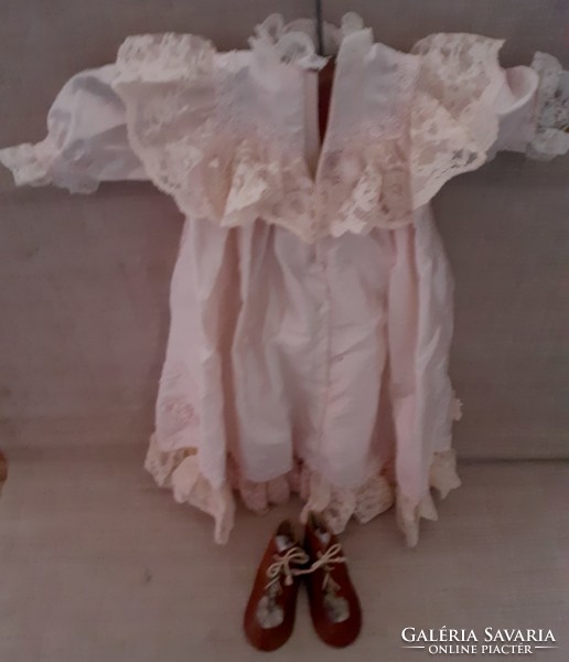Old spared beautiful silk and chubby baby clothes with small leather shoes for it