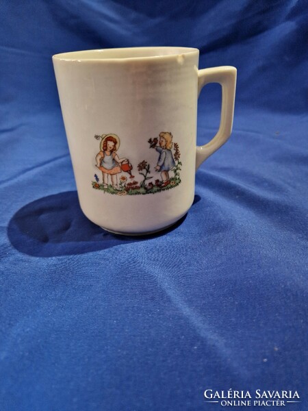 An old Zsolnay porcelain mug depicts two little girls, a fairy mug with a scene