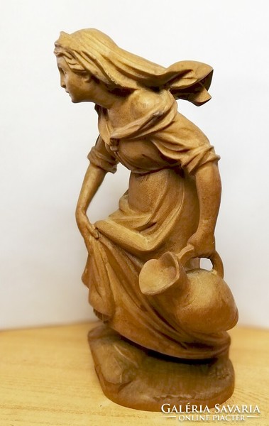 Antique carved statue. Girl with a jar of sandalwood wood