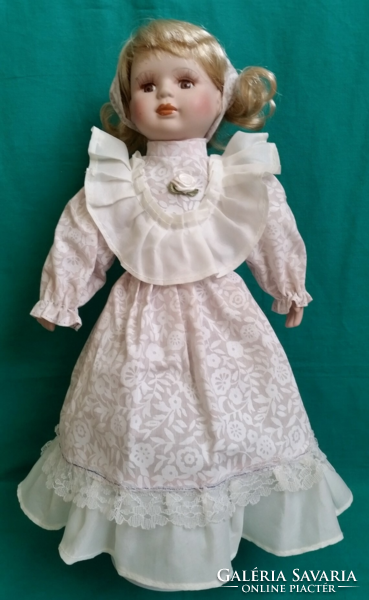 Old porcelain head blonde hair doll with a dreamy look, together with a stand
