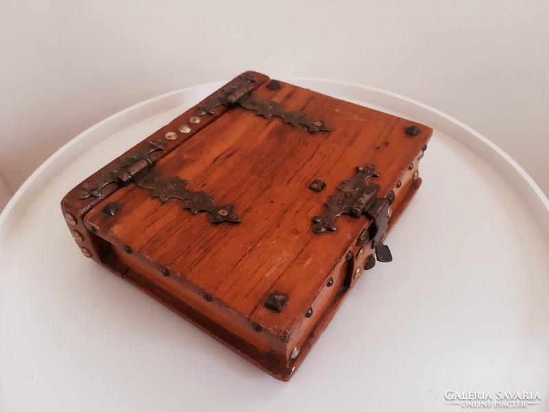 A wooden box with a buckle in the shape of a book