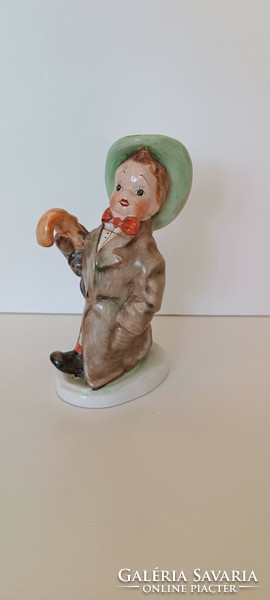 A boy in a green hat with an umbrella made by ceramic artist ksz