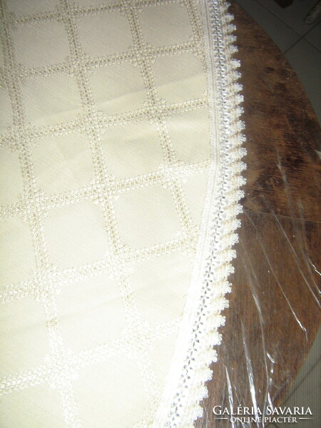 Beautiful round pale golden yellow woven tablecloth with a lace edge