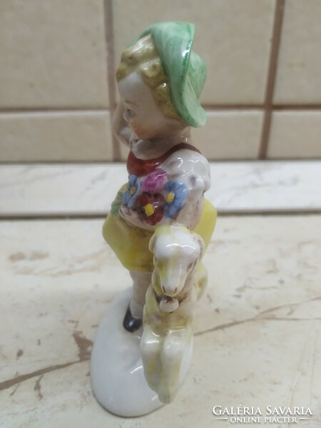 Little girl in a green hat with a toy statue! Antique porcelain statue, marked and numbered at the bottom for sale!