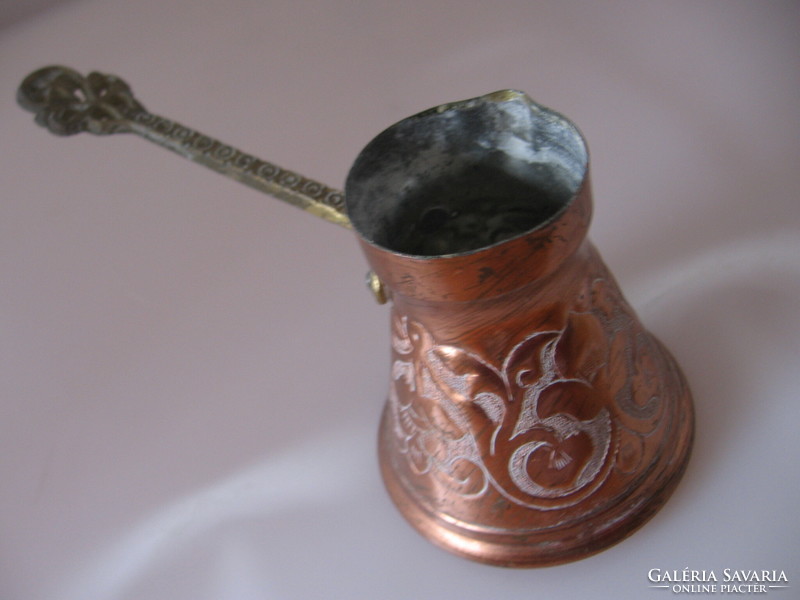 A copper kettle for Turkish coffee with a spout and a handle