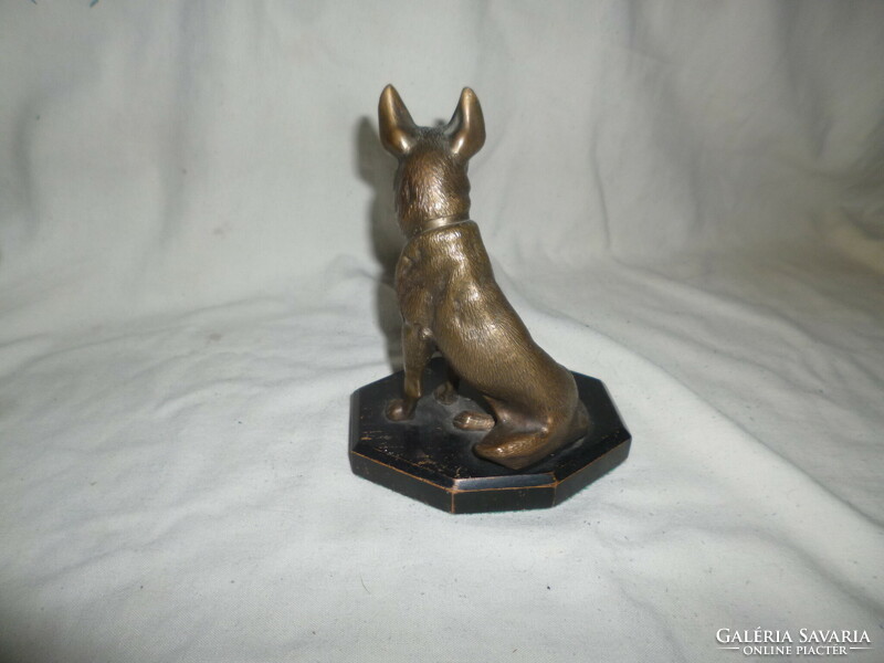 Old bronze German Shepherd dog statue on a wooden base