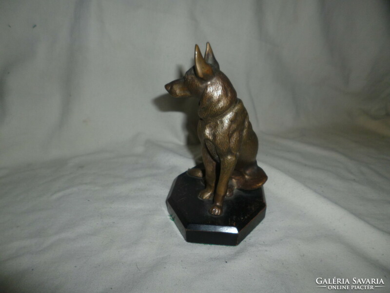 Old bronze German Shepherd dog statue on a wooden base