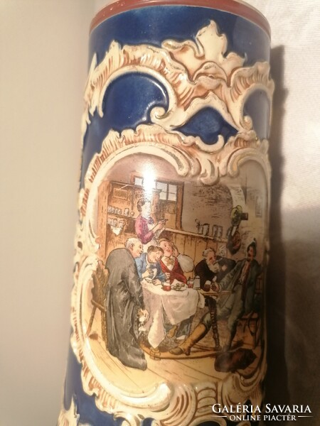 Antique German beer mug decorated with a painting of a pub - drinking scene, marked 1616 on the trunk.