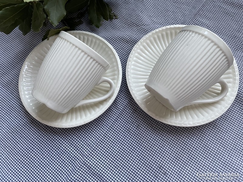 A pair of cream-colored mugs with ribbed walls and clean lines