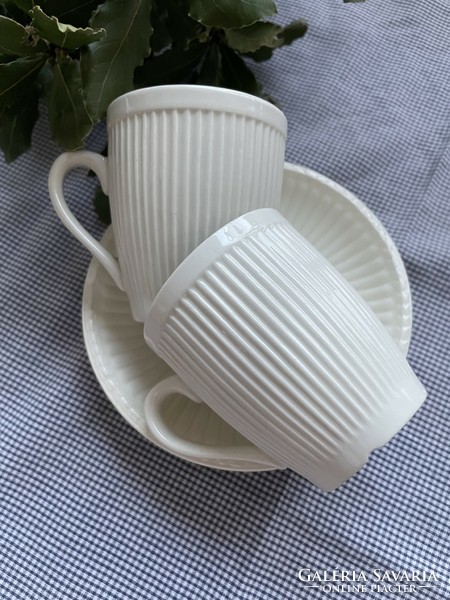 A pair of cream-colored mugs with ribbed walls and clean lines