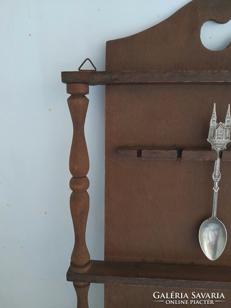 Wooden shelf holding a souvenir spoon