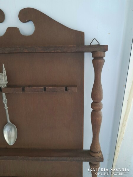 Wooden shelf holding a souvenir spoon