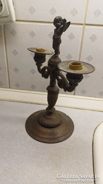 Antique angel statue, on top of the candle holder. Two arms.
