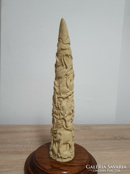Carved elephant tusk on a sophisticated wooden base.