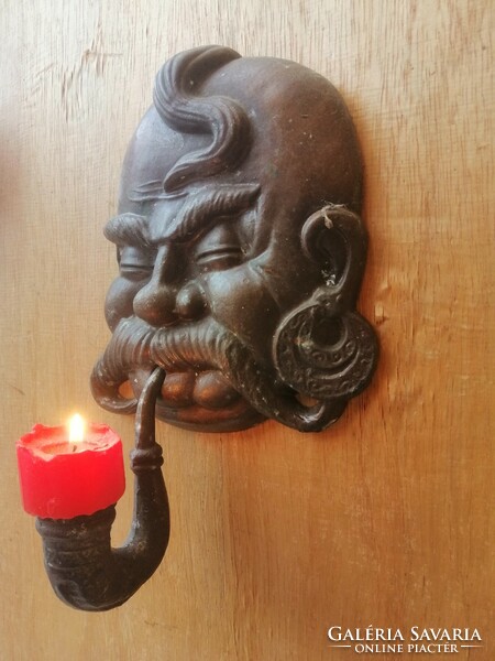 A cheerful Cossack candle holder with a pipe. Casting.