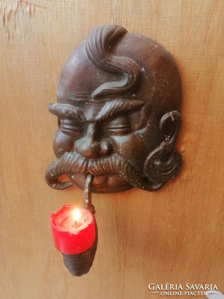 A cheerful Cossack candle holder with a pipe. Casting.