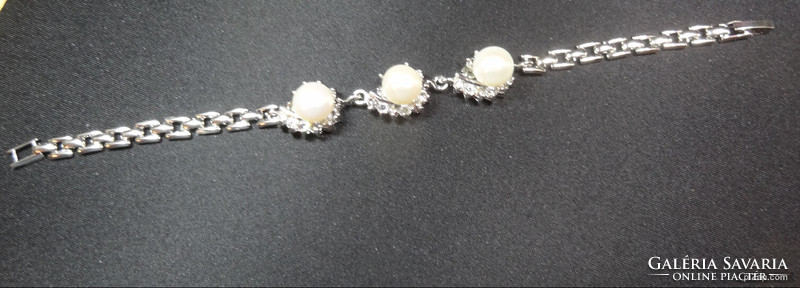 Akoya salt water cultured pearl set in medical grade metal bracelet with crystals around it.