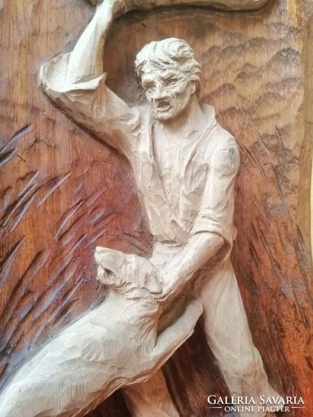 Toldi fighting with wolves. Wood carving
