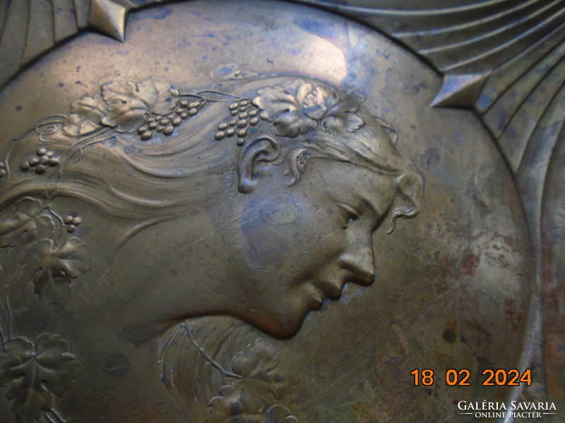 Characteristic art nouveau bowl with repoussé profile of a lady with grape leaves and curls in her hair.