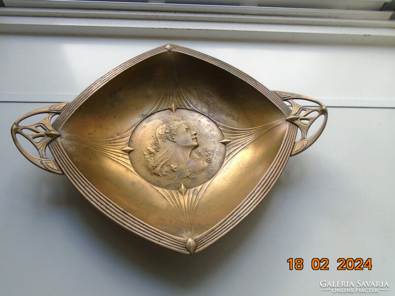 Characteristic art nouveau bowl with repoussé profile of a lady with grape leaves and curls in her hair.