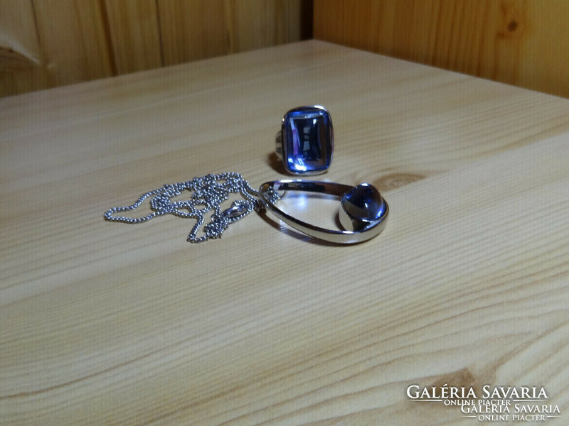 Uniquely designed pendant and ring set with aquamarine colored crystal, made of polished medical grade steel.