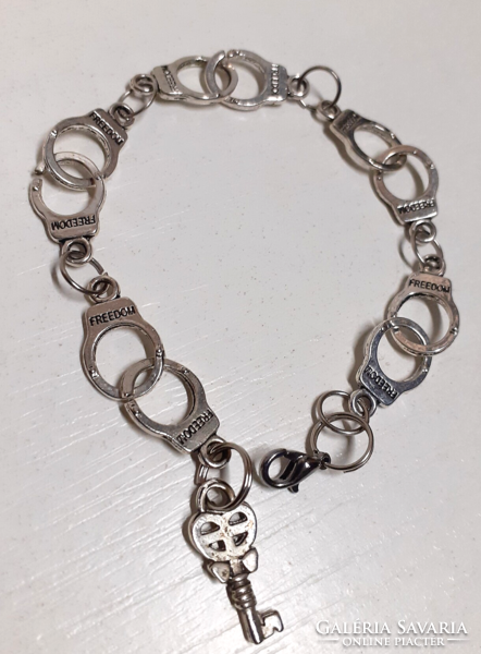 Szép állpotú ezüst színű Freedom  rozsdamentes acél bilincs karkötő kis kulcs medálionnal