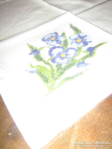 A small table napkin with pansies embroidered with a charming small cross stitch
