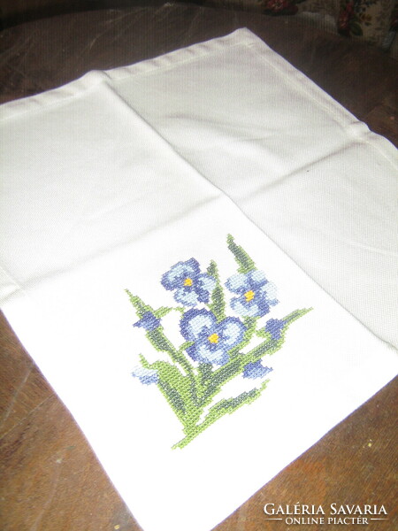 A small table napkin with pansies embroidered with a charming small cross stitch