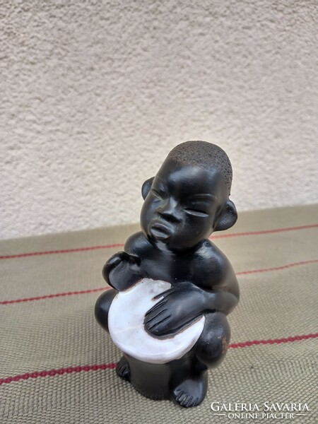 African boy playing terracotta drums. Design: Leopold Anzengruber. Negotiable!