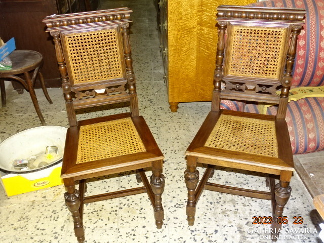A pair of pewter wicker dining chairs with backs