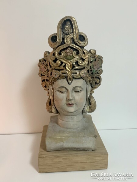 Hand-painted concrete Buddha head, statue on a wooden plinth