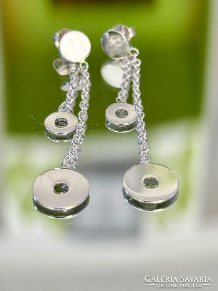 A pair of dangling silver earrings with a clean shape