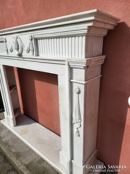 Classic marble fireplace with an antique portrait