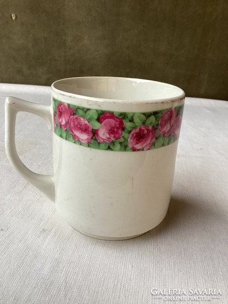 Old porcelain mug with rose pattern.