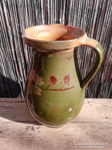 Old green jug with floral pattern