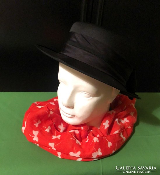 Elegant, branded black women's hat with a red patterned scarf.