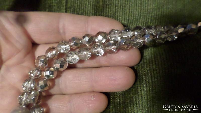 51 cm-es , ezüstösen lüszteres és nagyobb víztiszta üveggyöngyökből álló nyaklánc .