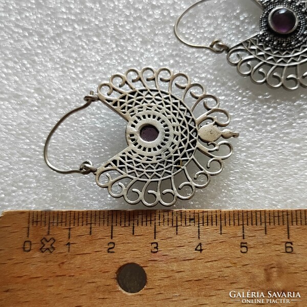 Beautiful metal earrings with a purple stone