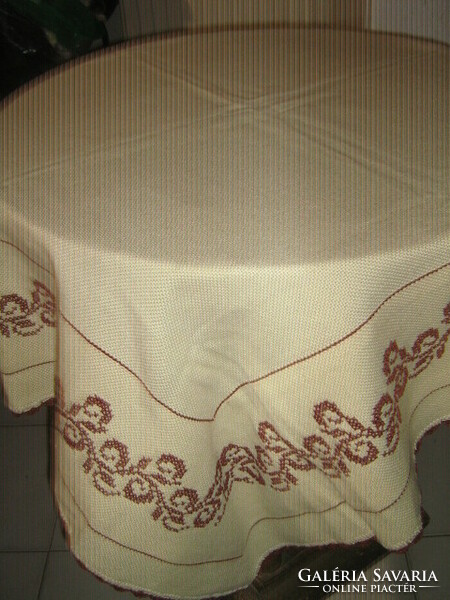 A beautiful hand-embroidered, lined woven tablecloth with a crocheted edge