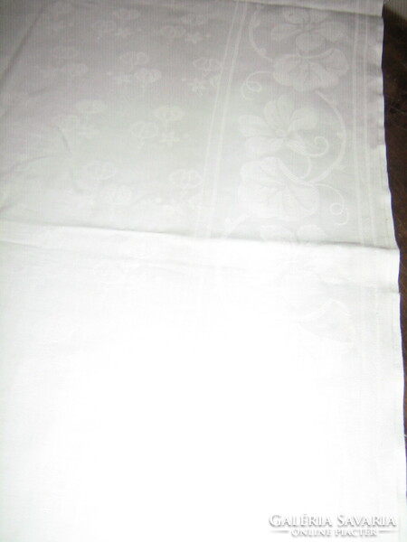A beautiful antique round damask tablecloth with a small flower pattern in the center