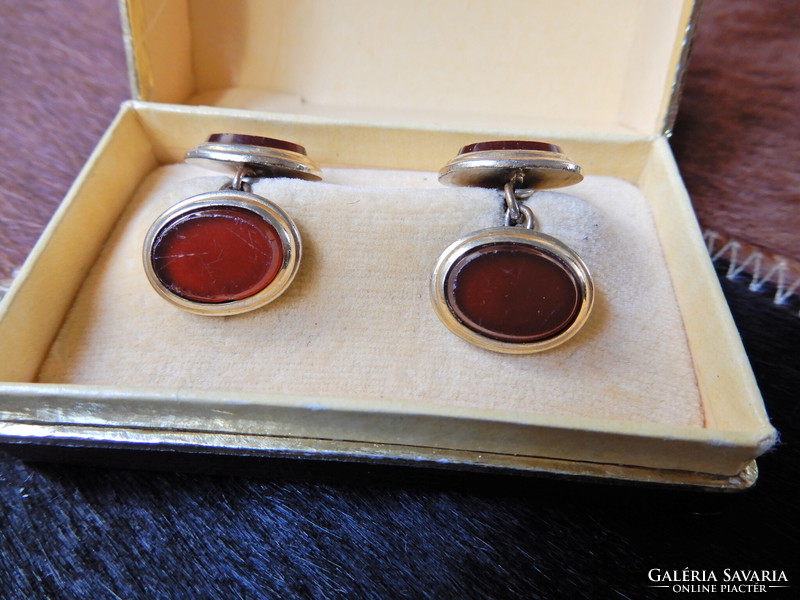 Old gold-plated cufflinks with a pair of red glass stones