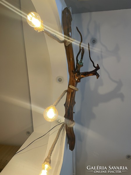 A unique ceiling lamp hanging on a chain made of yew roots,