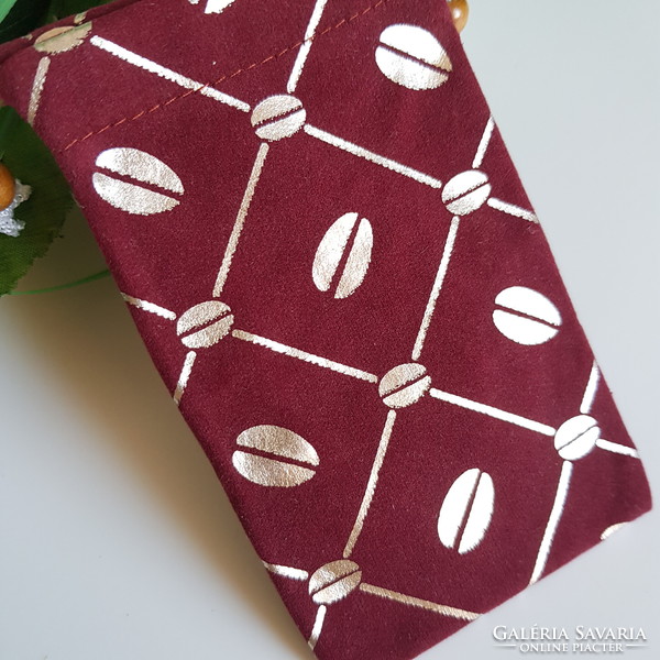 New retro textile phone case with gold coffee bean pattern on a burgundy base with a cord that can be hung around the neck